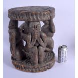 AN EARLY 20TH CENTURY AFRICAN YORUBA TRIBAL STOOL formed with four opposing figures. 38 cm x 26 cm.