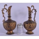 A PAIR OF EARLY 19TH CENTURY MIDDLE EASTERN TINNED BRASS EWERS decorated with buddhistic figures and