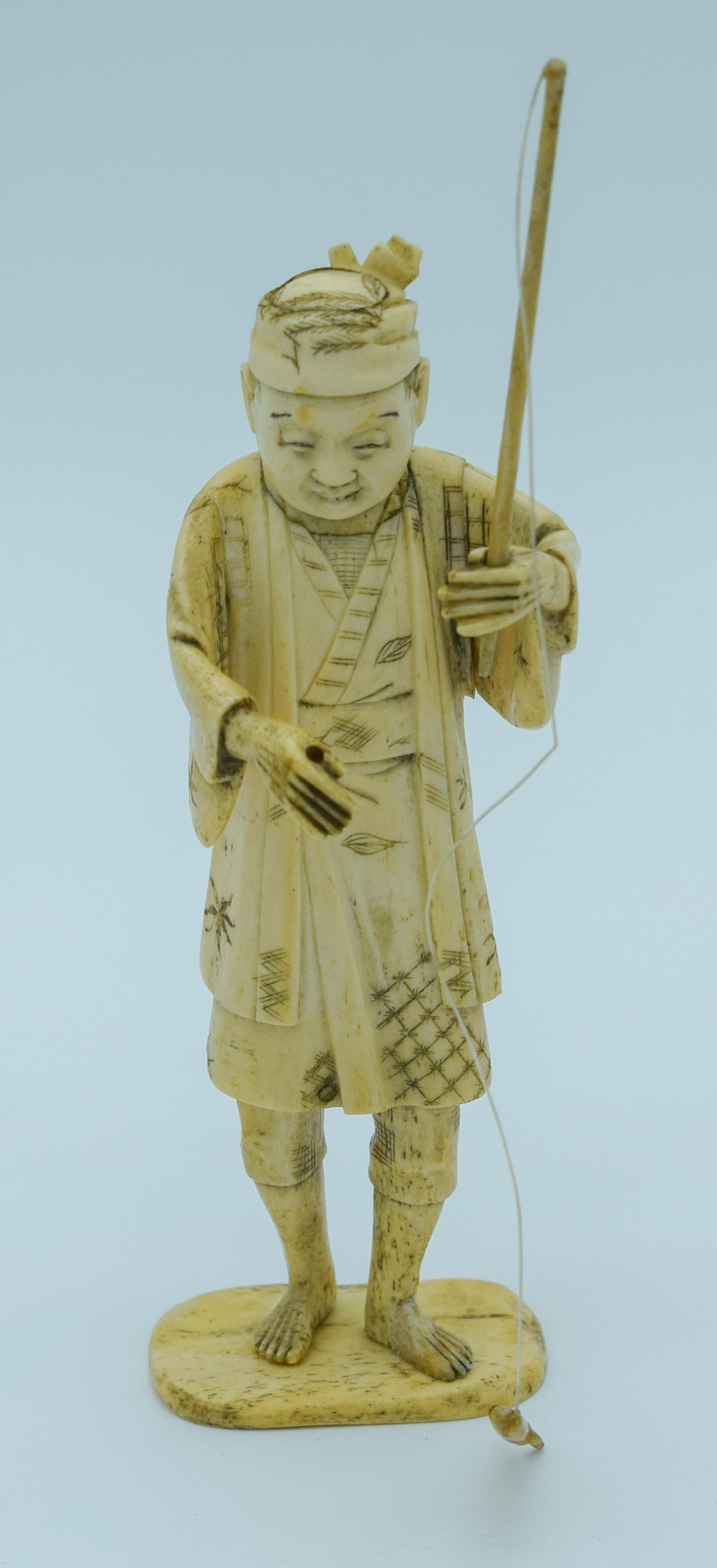 A small Japanese Meiji Period Ivory figure of a fisherman 20cm .