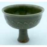 A Chinese celadon stem cup with embossed carp and scales in relief