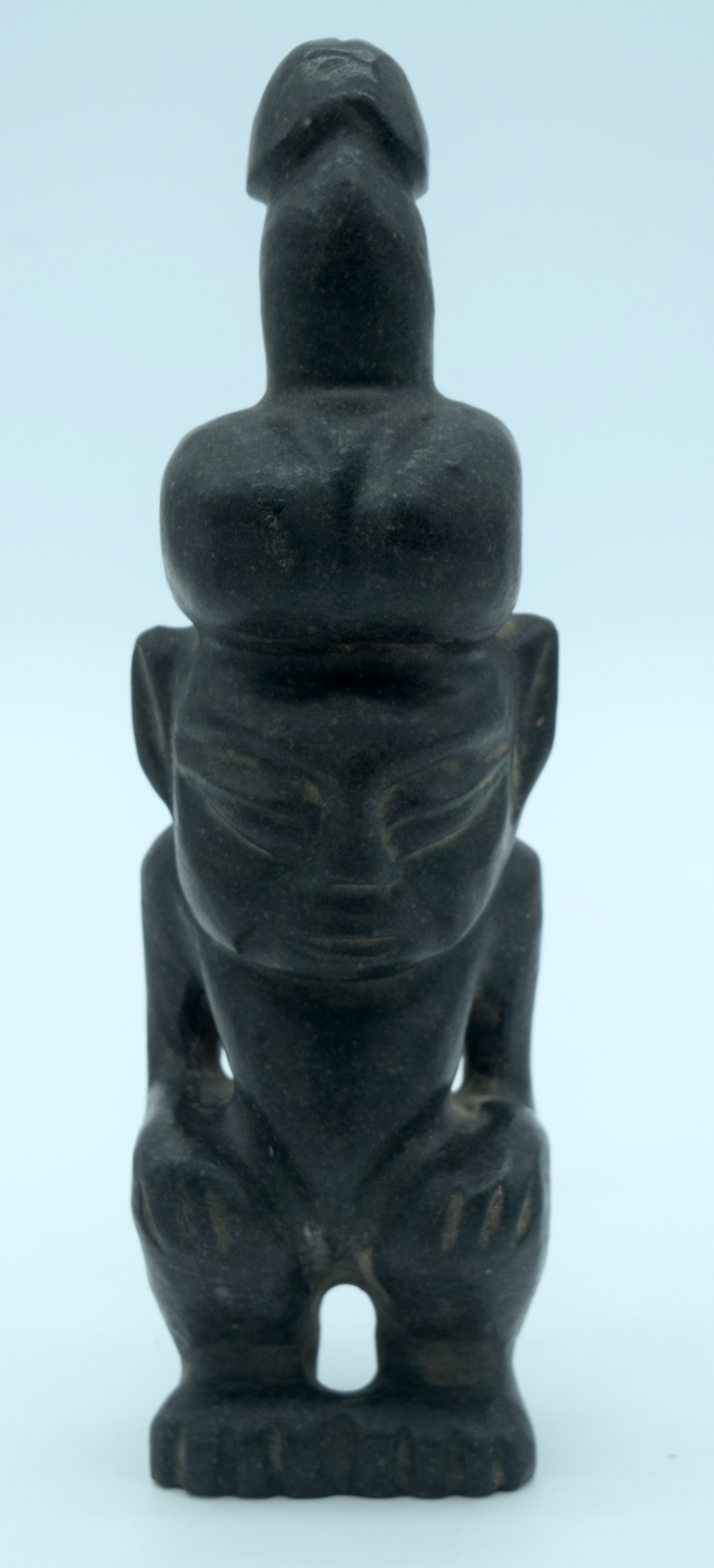 A Chinese hard stone statue of a male with a penis on his head 26 x 7cm.
