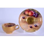 A ROYAL WORCESTER CUP AND SAUCER, the cup painted inside and with gold outside, both with fruit by H
