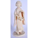A 19TH CENTURY JAPANESE MEIJI PERIOD CARVED IVORY OKIMONO modelled as a standing geisha. 17 cm high.