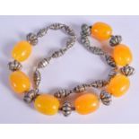 A SILVER AND AMBER NECKLACE. 101 grams. 60 cm long, largest bead 2.5 cm x 2 cm.