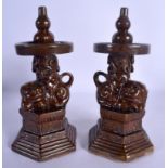 A PAIR OF 19TH CENTURY CHINESE BROWN GLAZED POTTERY PRICKET CANDLESTICKS formed with buddhistic lion