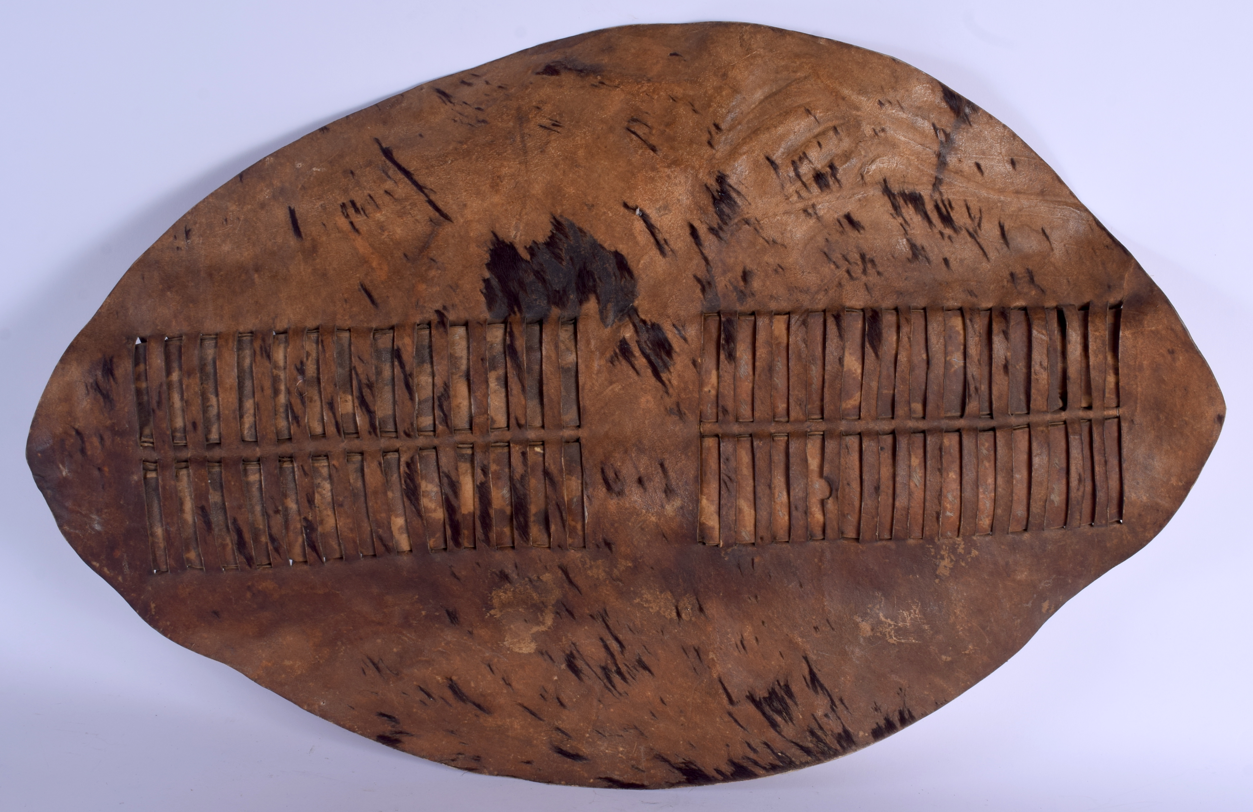 AN UNUSUAL TRIBAL HIDE SHIELD. 58 cm x 40 cm.