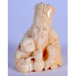 A 19TH CENTURY JAPANESE MEIJI PERIOD CARVED IVORY NETSUKE formed as a seated scholar. 4.25 cm x 3 cm