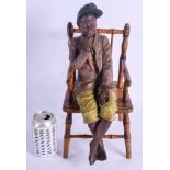 A RARE 19TH CENTURY AUSTRIAN PAINTED TERRACOTTA FIGURE OF A BOY modelled upon a chair. Figure 38 cm