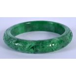 A CHINESE CARVED JADEITE BANGLE 20th Century. 7.5 cm diameter.