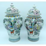 A near pair of large Chinese porcelain vases and covers bearing Kangxi marks depicting eight immort