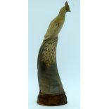A carved horn bird on a wooden stand 28cm.