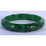 A CHINESE CARVED JADEITE BANGLE 20th Century. 7.5 cm diameter.