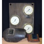 Collection of vintage welding equipment including masks and mounted brass cased Gauges
