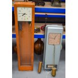 TWO LARGE VINTAGE ELECTRIC CLOCKS one wood cased, the other tin cased. Largest 128 cm x 28 cm. (2)