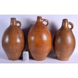 A LARGE SET OF THREE 19TH CENTURY ENGLISH STONEWARE BELLERMINE TYPE JUGS two with scratched numerals