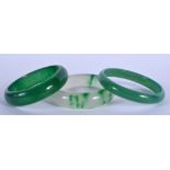 THREE CHINESE CARVED JADEITE BANGLES. 6.5 cm diameter. (3)