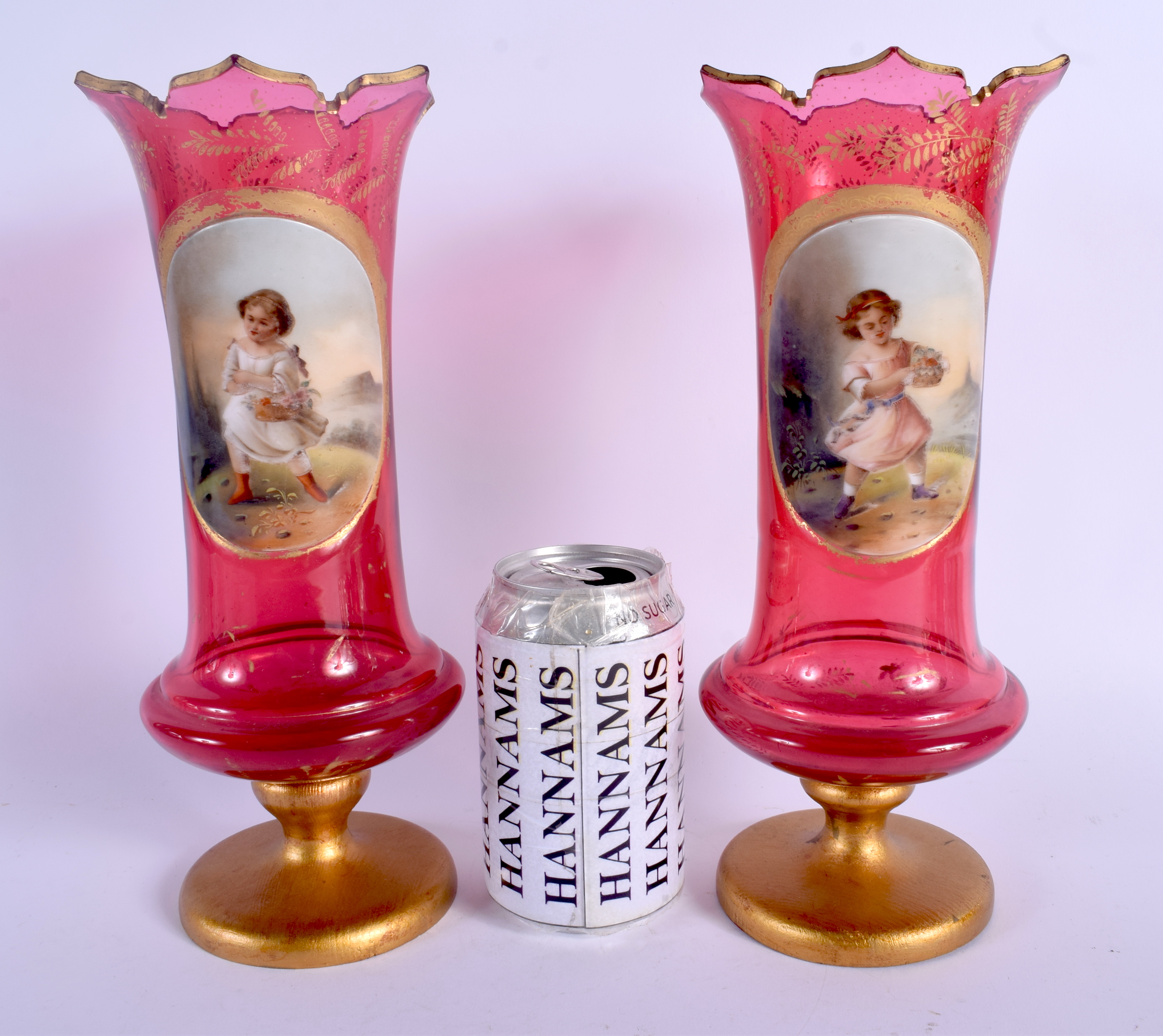 A PAIR OF 19TH CENTURY BOHEMIAN RUBY GLASS VASES painted with girls within landscapes. 27 cm high.