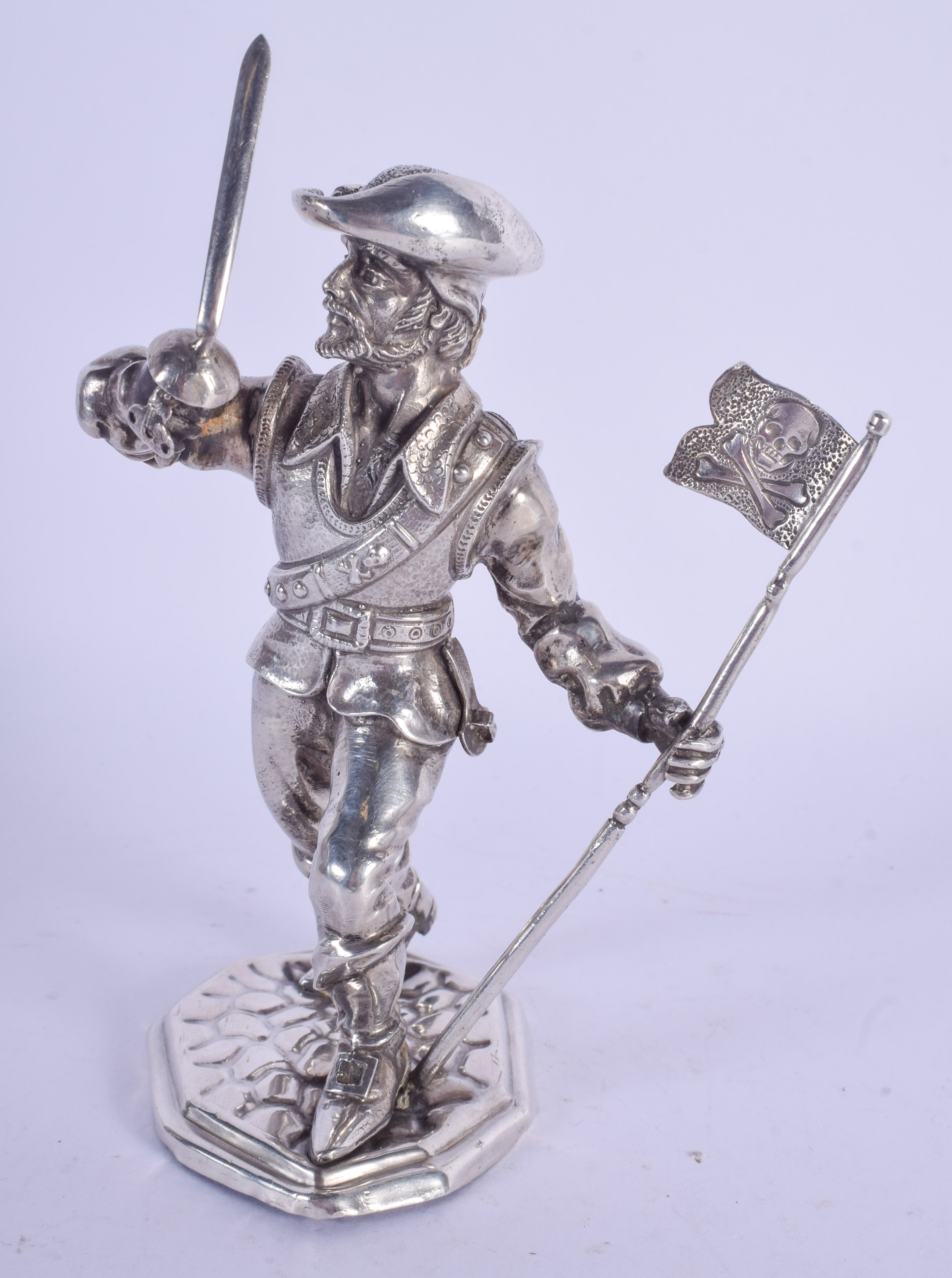 AN UNUSUAL EARLY 20TH CENTURY CONTINENTAL SILVER FIGURE OF A PIRATE modelled holding a flag. 150 gra