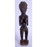 AN AFRICAN TRIBAL CARVED HARDWOOD FERTILITY FIGURE modelled holding her breasts. 24 cm high.