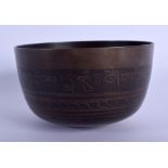 A 19TH CENTURY SINO TIBETAN BRONZE BUDDHISTIC ALMS BOWL decorated with script. 12.5 cm diameter.