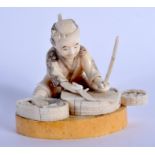 A 19TH CENTURY JAPANESE MEIJI PERIOD CARVED BONE FIGURE OF A MALE modelled preparing fish. 8 cm x 9