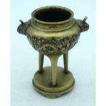 A Chinese Bronze tri pod censer embossed with a dragon pattern 13 x 10cm.