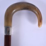 A 19TH CENTURY CONTINENTAL CARVED RHINOCEROS HORN WALKING CANE with silver mounts. 84 cm long.