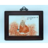 A framed Chinese porcelain panel depicting a figure and calligraphy 35 x 23 cm.