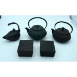 Three heavy cast iron metal Japanese tea pots together with two boxes . 18 x 9 cm (5).
