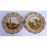 Late 19th c. Coalport pair of plates painted with landscapes surrounded by gilt panels and a pierced