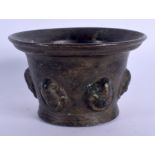 A 17TH/18TH CENTURY EUROPEAN BRONZE MORTAR decorated with mask heads. 9 cm x 6 cm.