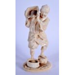 A 19TH CENTURY JAPANESE MEIJI PERIOD CARVED IVORY OKIMONO modelled as a male pouring grain. 14.5 cm