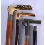 AN ANTIQUE ANTLER HORN HANDLED SILVER WALKING CANE together with three others. Largest 90 cm long. (