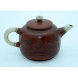 A Chinese Yixing tea pot with a mounted Jade handle and spout. 10 x 17cm.