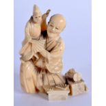 A 19TH CENTURY JAPANESE MEIJI PERIOD CARVED IVORY OKIMONO modelled as a male and a child. 8 cm x 5 c