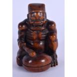 A 19TH CENTURY CARVED NUT OKIMONO modelled as a muscular. 9.5 cm x 5.5 cm.