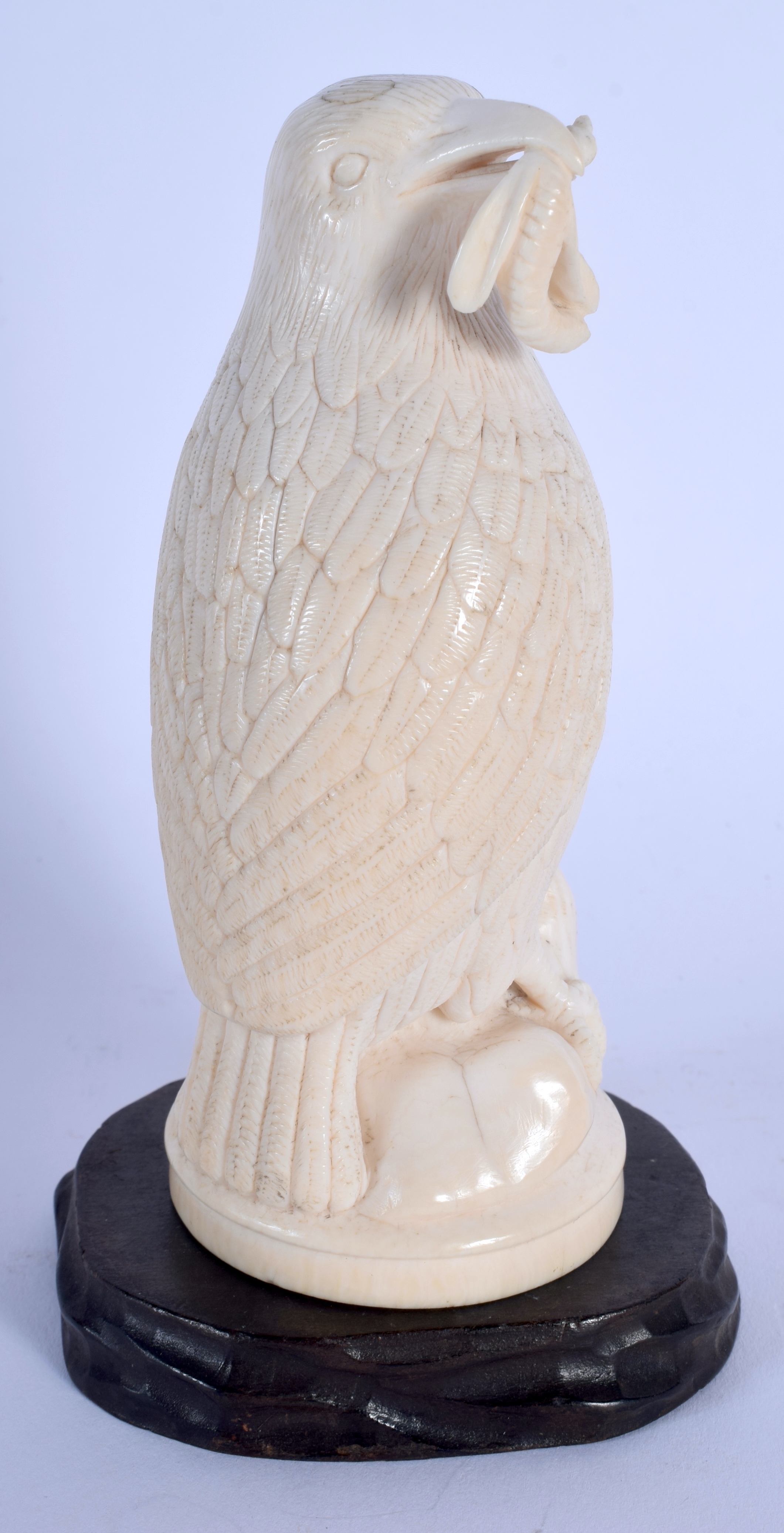 A 19TH CENTURY EUROPEAN CARVED IVORY FIGURE OF A BIRD modelled holding an insect within its mouth. 1