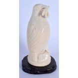 A 19TH CENTURY EUROPEAN CARVED IVORY FIGURE OF A BIRD modelled holding an insect within its mouth. 1