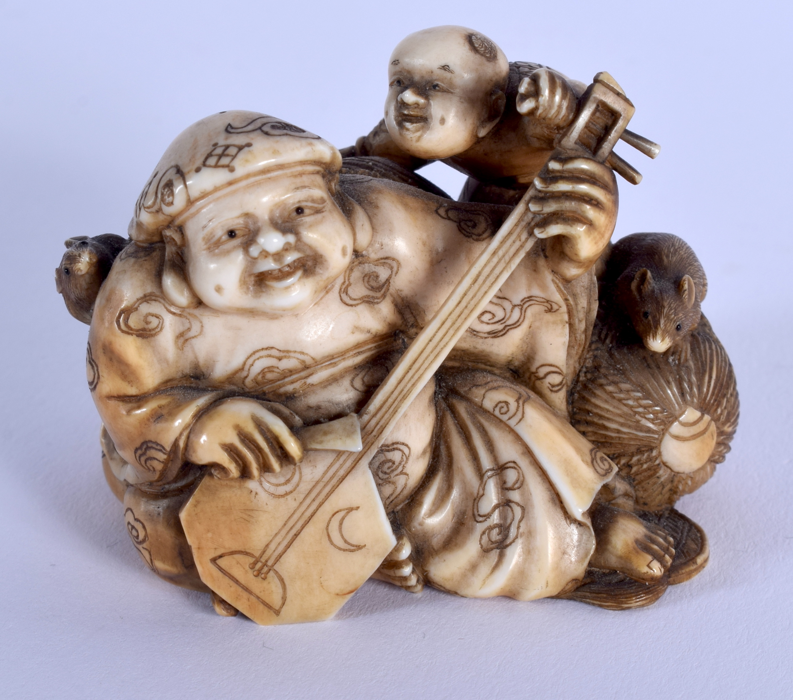 A 19TH CENTURY JAPANESE MEIJI PERIOD CARVED IVORY OKIMONO modelled as a male playing an instrument.