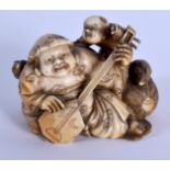 A 19TH CENTURY JAPANESE MEIJI PERIOD CARVED IVORY OKIMONO modelled as a male playing an instrument.