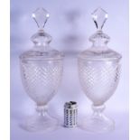 A PAIR OF CUT GLASS STORM LAMPS AND COVERS. 53 cm high.