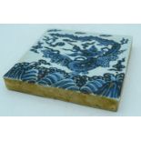 A Chinese blue and white temple tile decorated with a dragon 20 x 20cm.