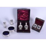 A CASED PAIR OF SILVER CONDIMENTS Birmingham 1876 & a pair of Napkin rings Sheffield 1897 & a plated