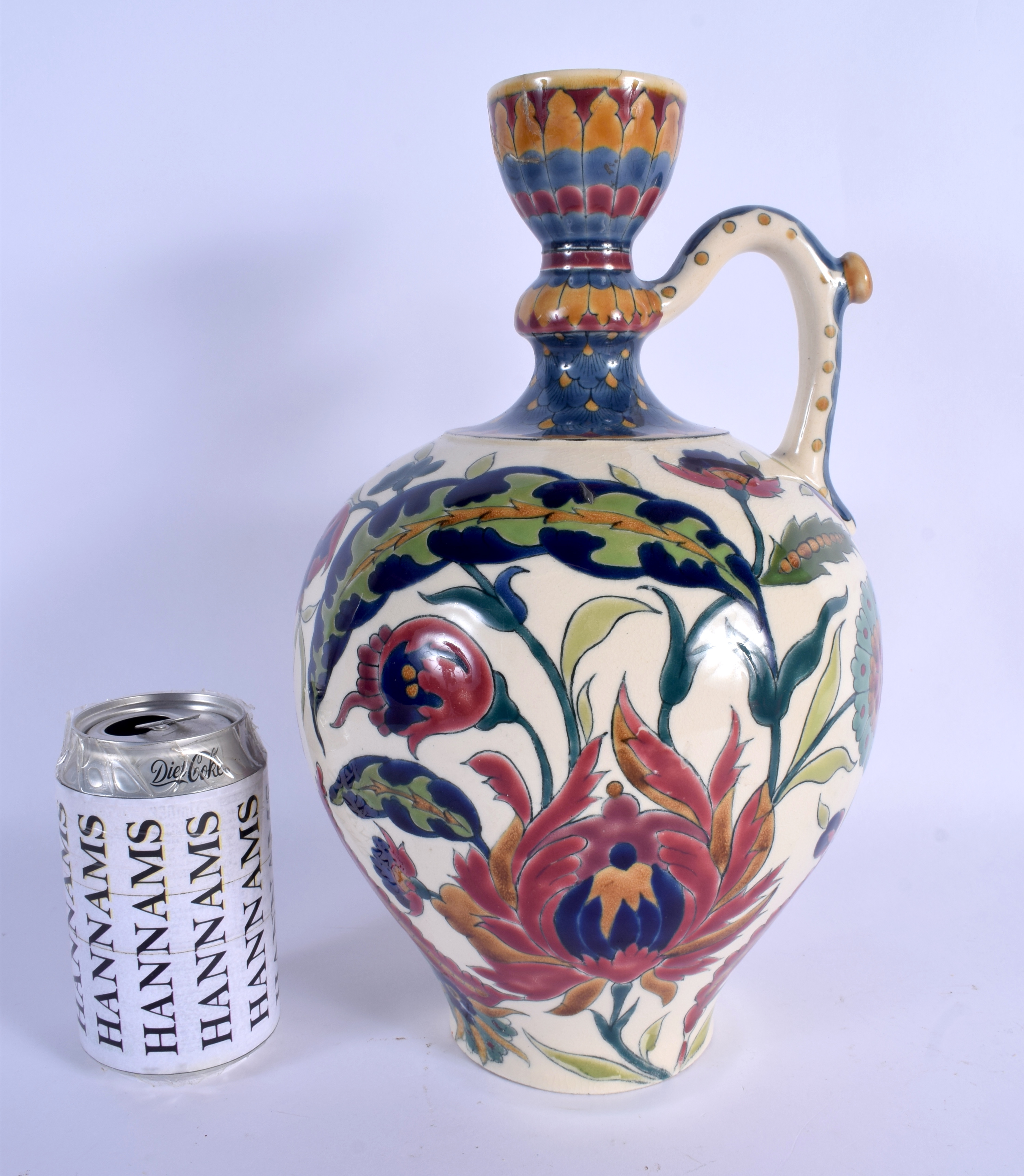 AN ANTIQUE HUNGARIAN ZSOLNAY PECS POTTERY EWER painted with stylised flowers and vines. 32 cm high.