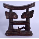 AN AFRICAN TRIBAL CARVED DOUBLE FIGURAL FORM HEAD REST modelled opposing upon an oval base. 13 cm x