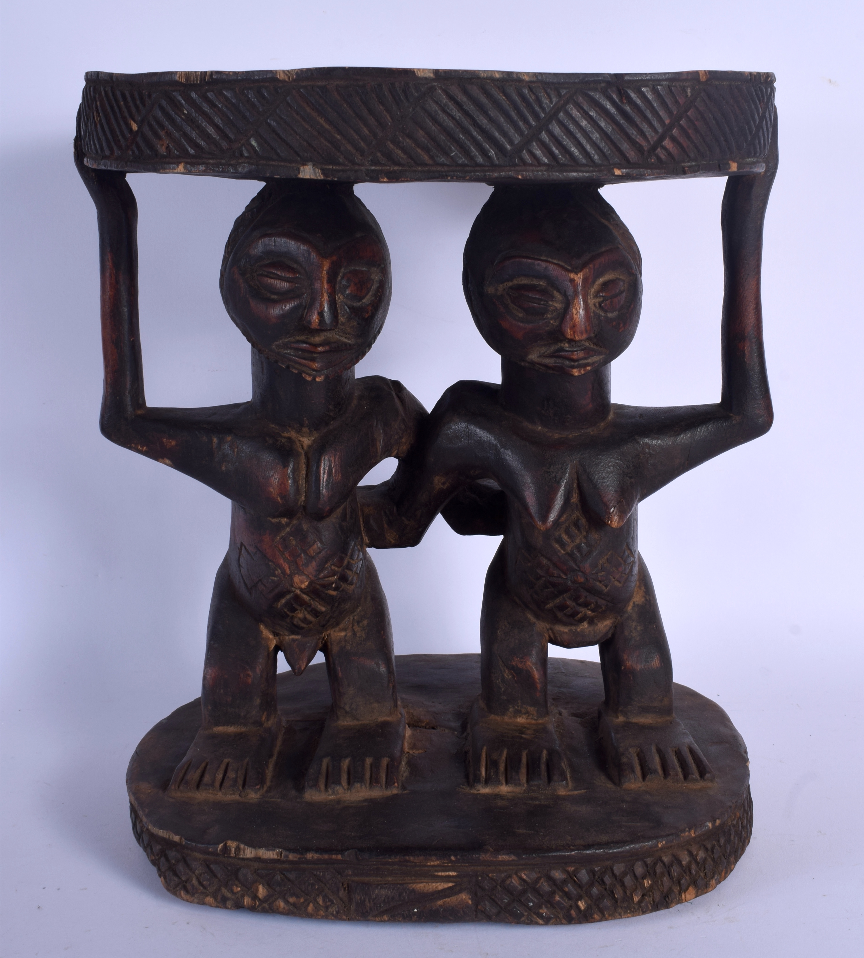 AN UNUSUAL AFRICAN CARVED TRIBAL YORUBA STOOL formed as male and female beside each other. 36 cm x 3
