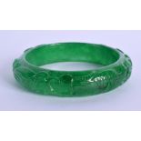 A CHINESE CARVED APPLE JADEITE BANGLE 20th Century. 7 cm wide.