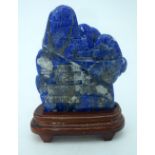 A carved Lapis Lazuli boulder mounted on a stand 17 x 13cm.