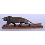 A 19TH CENTURY MIDDLE EASTERN CARVED RHINOCEROS HORN FIGURE OF A ROAMING LION modelled upon a wooden