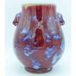 A Chinese Flambe glazed vase with elephant head handles 27cm.